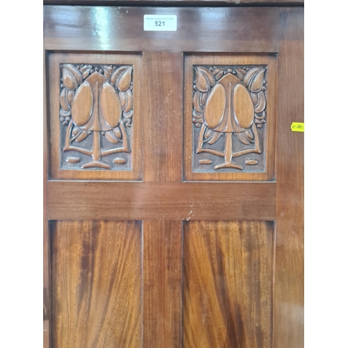 521 - An Art Nouveau style mahogany Wardrobe the central door with carved stylised tree panels, above open... 