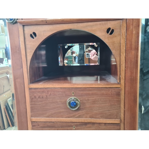 521 - An Art Nouveau style mahogany Wardrobe the central door with carved stylised tree panels, above open... 