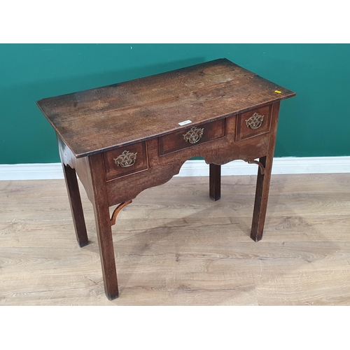 60 - An 18th Century oak Lowboy fitted three drawers around a shaped apron with pierced corner brackets o... 