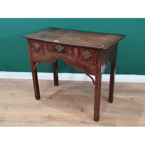 60 - An 18th Century oak Lowboy fitted three drawers around a shaped apron with pierced corner brackets o... 