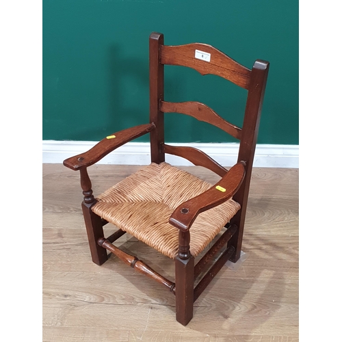 8 - An oak rush seated child's Elbow Chair 2ft 2in H x 1ft 5in W (R4)