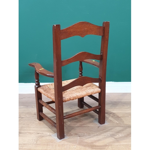 8 - An oak rush seated child's Elbow Chair 2ft 2in H x 1ft 5in W (R4)