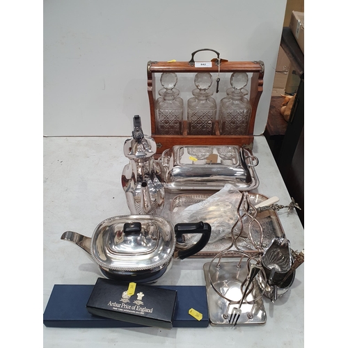 842 - An oak Tantalus with three decanters, a silver plated four piece Tea Service, Entre Dish and Cover, ... 