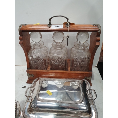 842 - An oak Tantalus with three decanters, a silver plated four piece Tea Service, Entre Dish and Cover, ... 