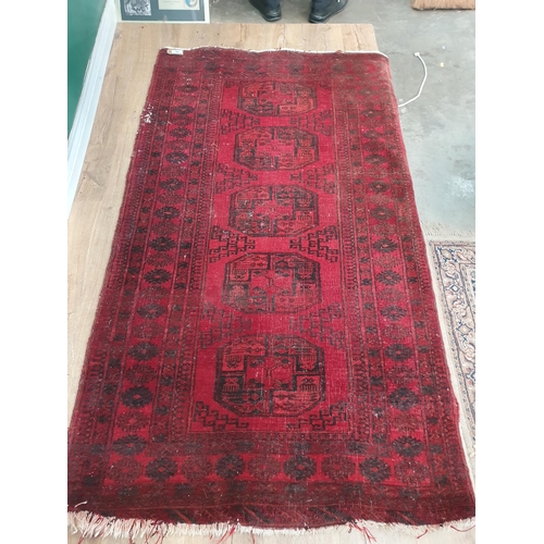 889 - A Turkish Rug with multiple borders, and decorated medallions on a red ground, A/F 6ft 1in x 3ft 5in... 