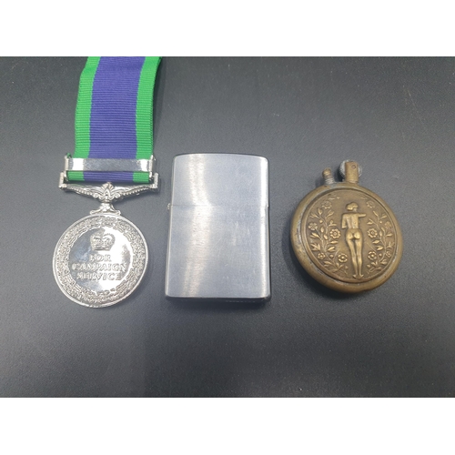 95 - A reproduction Northern Ireland Campaign Medal, a Trench Art Lighter and a Zippo Lighter