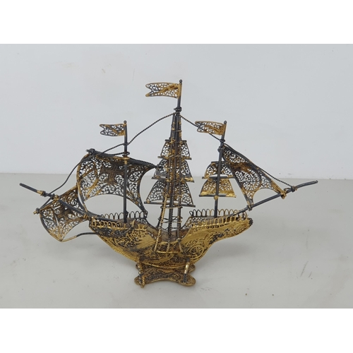 99 - A gilt and white metal filigree three masted sailing Vessel with red and white enamel cross, 4in