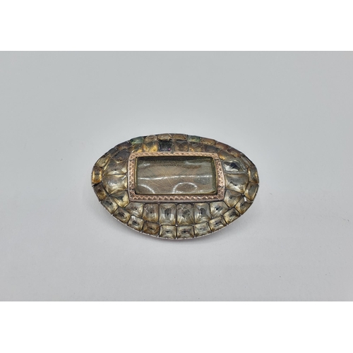 185 - A Georgian oval Mourning Brooch with lock of hair to centre within foil backed paste, approx 48mm wi... 