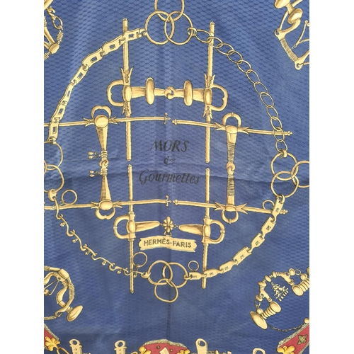 248 - A vintage Hermes silk Scarf; 'MORS & Gourmettes' printed various bridles in gold and red on blue tex... 