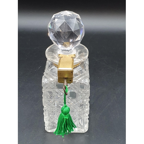 106 - A small cut glass square Decanter and Stopper with gilt metal Betjemann lock and key, with silver Wh... 