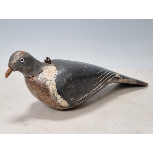 19 - A carved and painted English Pigeon Decoy with inset glass eyes and rig eyelets, with associated woo... 