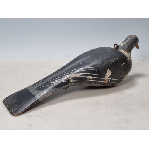 19 - A carved and painted English Pigeon Decoy with inset glass eyes and rig eyelets, with associated woo... 