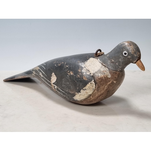 19 - A carved and painted English Pigeon Decoy with inset glass eyes and rig eyelets, with associated woo... 