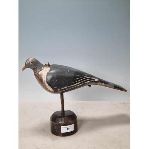 19 - A carved and painted English Pigeon Decoy with inset glass eyes and rig eyelets, with associated woo... 