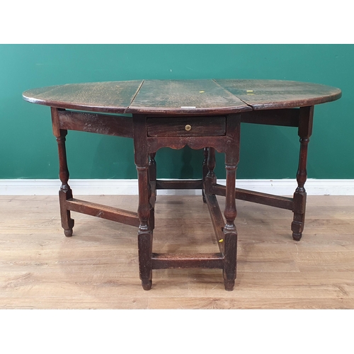 3 - An oak Gateleg Table with single fitted drawer, above cupids bow frieze, raised on turned supports, ... 