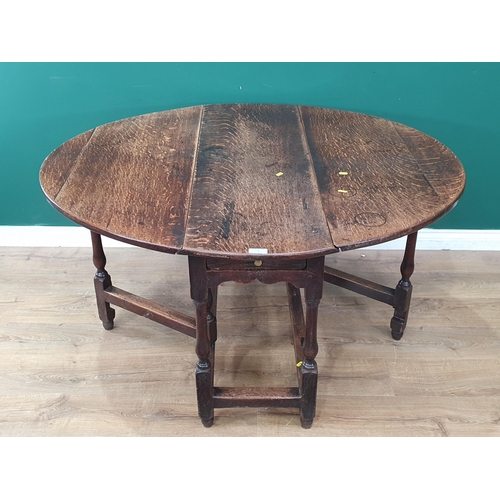 3 - An oak Gateleg Table with single fitted drawer, above cupids bow frieze, raised on turned supports, ... 