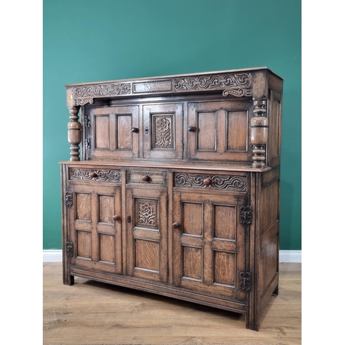 37 - A Reproduction oak Court Cupboard with carved frieze above pair of panel doors flanking central flor... 