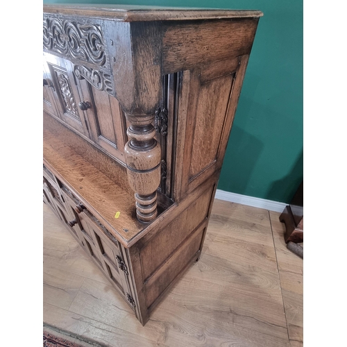 37 - A Reproduction oak Court Cupboard with carved frieze above pair of panel doors flanking central flor... 