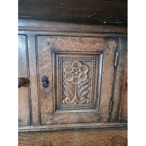 37 - A Reproduction oak Court Cupboard with carved frieze above pair of panel doors flanking central flor... 