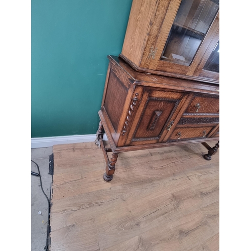 427 - An oak Sideboard fitted two central drawers flanked by a pair of cupboard doors with carved moulded ... 