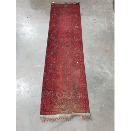 53 - A Red Turkoman Runner with multiple borders, and rows of small medallions on a red ground, 9ft 8in x... 