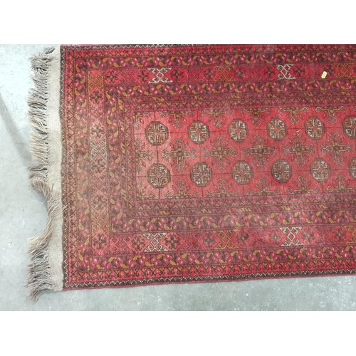 53 - A Red Turkoman Runner with multiple borders, and rows of small medallions on a red ground, 9ft 8in x... 