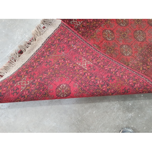 53 - A Red Turkoman Runner with multiple borders, and rows of small medallions on a red ground, 9ft 8in x... 