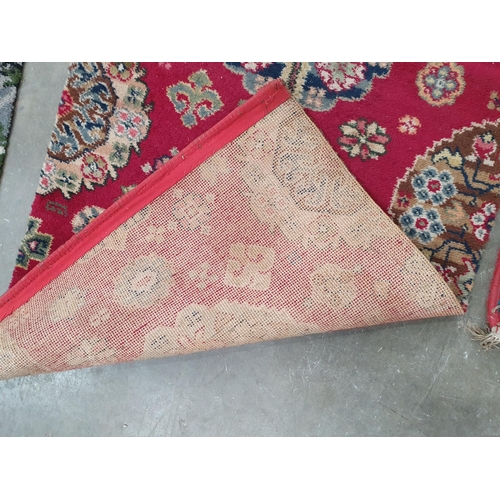 54 - A small Persian Rug with three oval medallions on a pale red ground, 5ft 3in x 3ft 9in two floral Ru... 