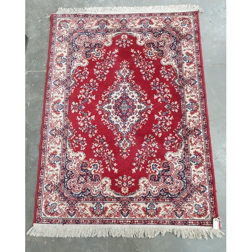 55 - A Persian style Rug with floral and scrolled design on a red ground, 5ft 5in x 3ft 11in