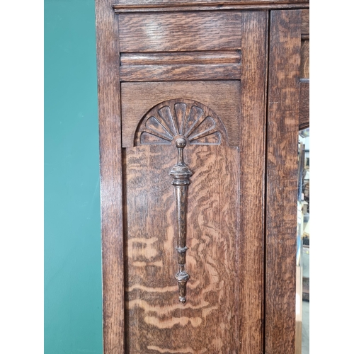 576 - An oak Wardrobe with moulded cornice above inlaid floral floral frieze, with arched bevelled mirror ... 