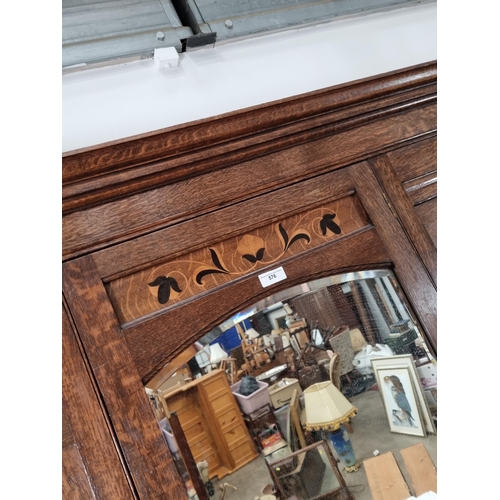 576 - An oak Wardrobe with moulded cornice above inlaid floral floral frieze, with arched bevelled mirror ... 