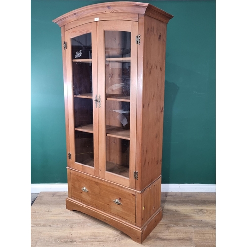 595 - A modern Marks and Spencer pine Display Cabinet with arched top, above pair of glazed doors enclosin... 