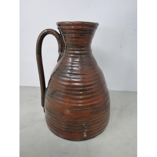 60 - Five Art Pottery Jugs with dark brown glazes, one with wheatear and leafage design, one by Leach wit... 