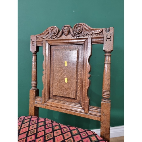 617 - A rustic oak Hall Chair with carved mask and scrolled surmount, fielded panel back, solid seat, on b... 