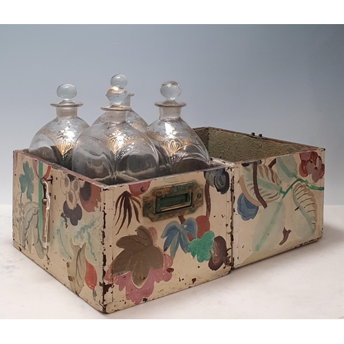 696 - An antique oak overpainted travelling bottle case with brass handles and key with four glass gilt-de... 