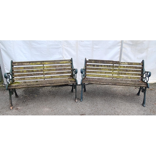 72 - A pair of green painted cast wooden slatted Garden Benches on decorative supports, A/F (Top Rail on ... 