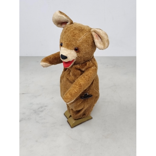 1388 - A clockwork tinplate Bear with plush fur covering 9in H