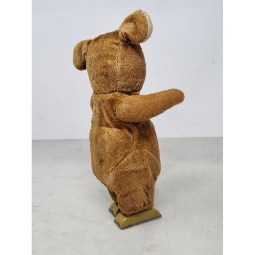 1388 - A clockwork tinplate Bear with plush fur covering 9in H