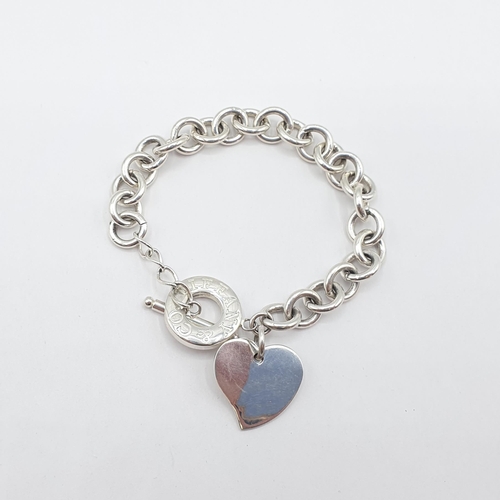 162 - A Tiffany & Co silver Bracelet stamped 925 with two heart shaped charms and a T-bar fastener, approx... 