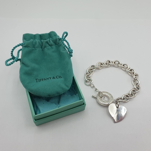 162 - A Tiffany & Co silver Bracelet stamped 925 with two heart shaped charms and a T-bar fastener, approx... 