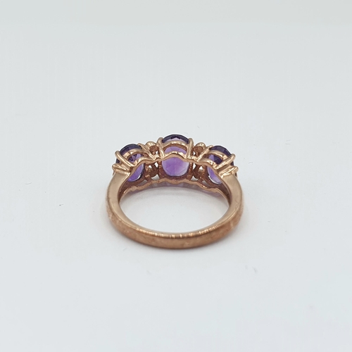 170 - An Amethyst and Diamond Ring claw-set three oval-cut amethysts interspersed with two small eight-cut... 