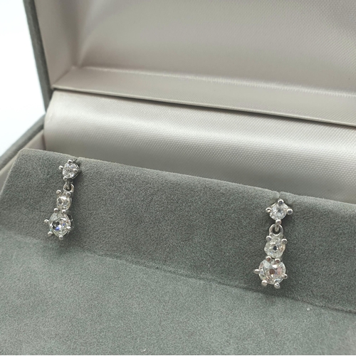 185 - A pair of diamond drop Earrings each claw-set three graduated old-cut stones in platinum, estimated ... 