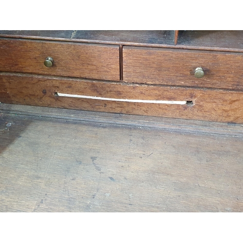 454 - A carved oak Bureau with fall front enclosing pigeonhole and drawer interior above four long graduat... 