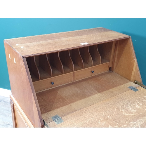 462 - An oak Deco style Bureau the fall front enclosing pigeonhole and two fitted drawers, the base with p... 