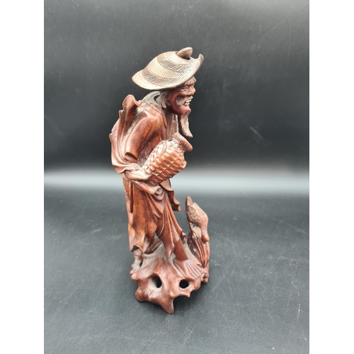 51 - A carved Oriental wooden Figure of bearded gent feeding bird, 12in (R1)