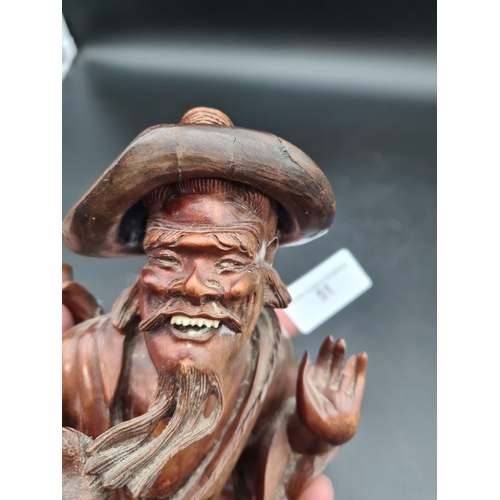 51 - A carved Oriental wooden Figure of bearded gent feeding bird, 12in (R1)