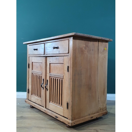 675 - A pine Cupboard fitted two short drawers over pair of pierced panel doors, on turned bun feet, 33