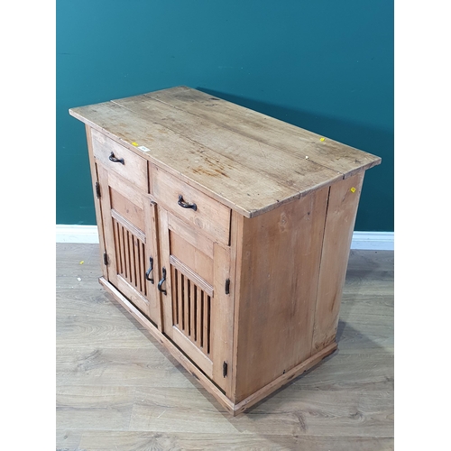 675 - A pine Cupboard fitted two short drawers over pair of pierced panel doors, on turned bun feet, 33