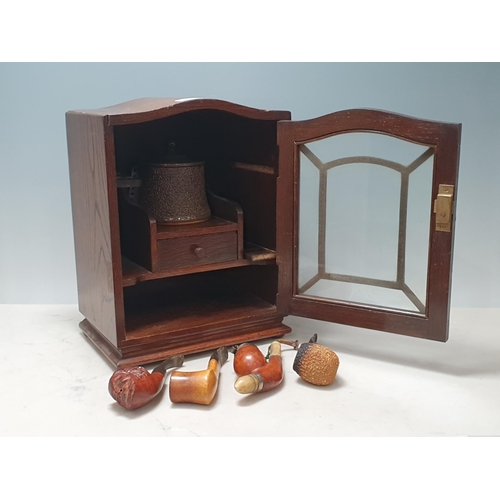 9 - An oak and glazed Smoker's Cabinet with fitted shelves and drawer to interiors and stoneware lidded ... 