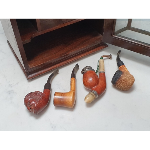 9 - An oak and glazed Smoker's Cabinet with fitted shelves and drawer to interiors and stoneware lidded ... 